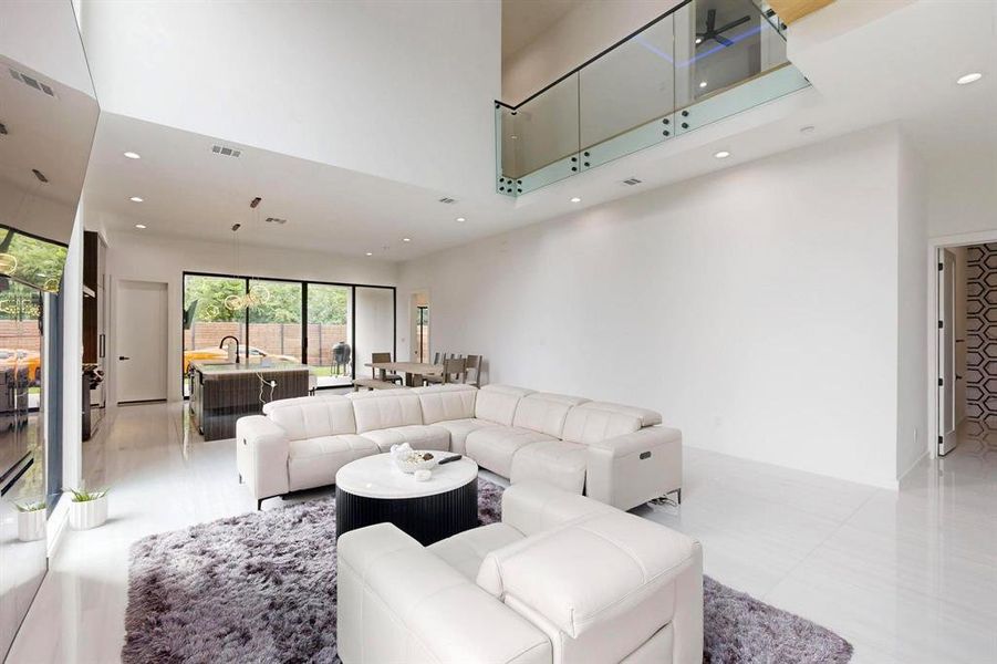 Living room featuring a towering ceiling, recessed lighting, and light tile patterned floors Living room featuring a towering ceiling, recessed lighting, and light tile patterned floors