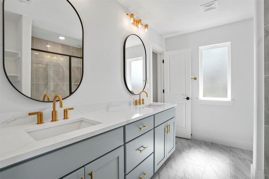 Bathroom featuring a shower stall, visible vents, marble finish floor, and a sink