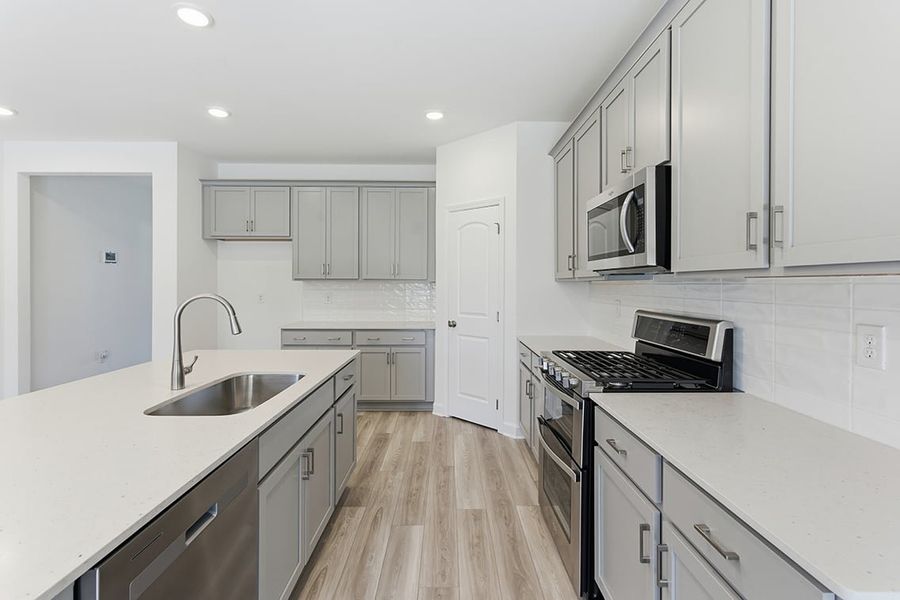 A kitchen with white cabinets.