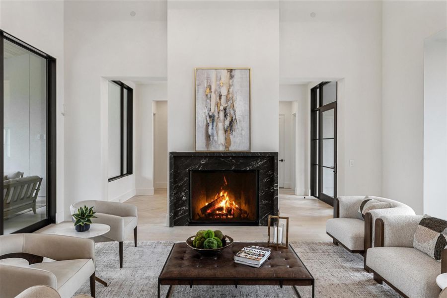 Living room featuring a high ceiling and a high end fireplace Living room featuring a high ceiling and a high end fireplace
