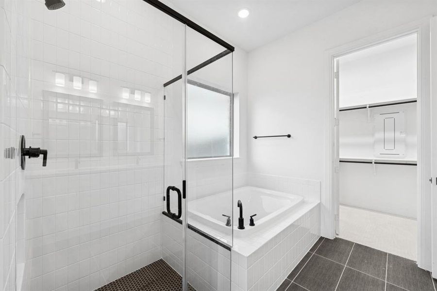 Full bathroom with a stall shower, a bath, recessed lighting, a walk in closet, and dark tile patterned flooring Full bathroom with a stall shower, a bath, recessed lighting, a walk in closet, and dark tile patterned flooring