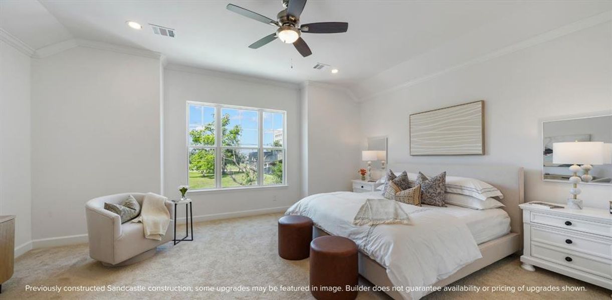 Primary Retreat: A spaciously lit sanctuary, complete with a ceiling fan for personalized comfort and views that take in a verdant, tree-lined lane.