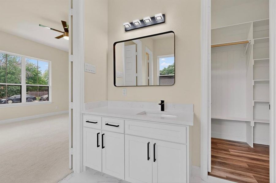 Single vanity with a rectangular sink and matte black faucet, featuring a framed mirror and modern light fixture