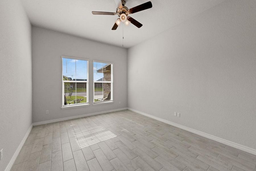 Empty room featuring wood finish floors and a ceiling fan