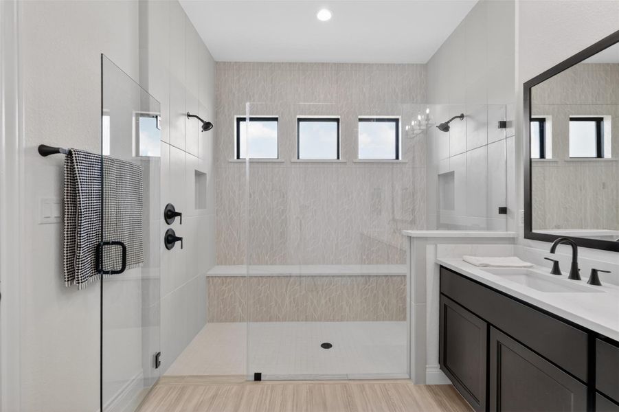 A well-appointed bath boasts a spacious walk-in shower with a built-in bench and a sleek vanity. A well-appointed bath boasts a spacious walk-in shower with a built-in bench and a sleek vanity.