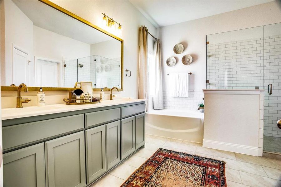 Bathroom featuring vanity, tile patterned floors, and shower with separate bathtub