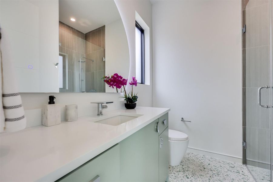 Terrazzo tile underfoot brings a mid-century warmth to this crisp, modern ensuite