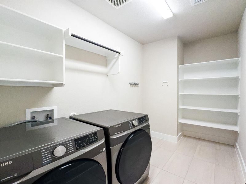 Laundry room featuring light tile patterned floors and separate washer and dryer Laundry room featuring light tile patterned floors and separate washer and dryer