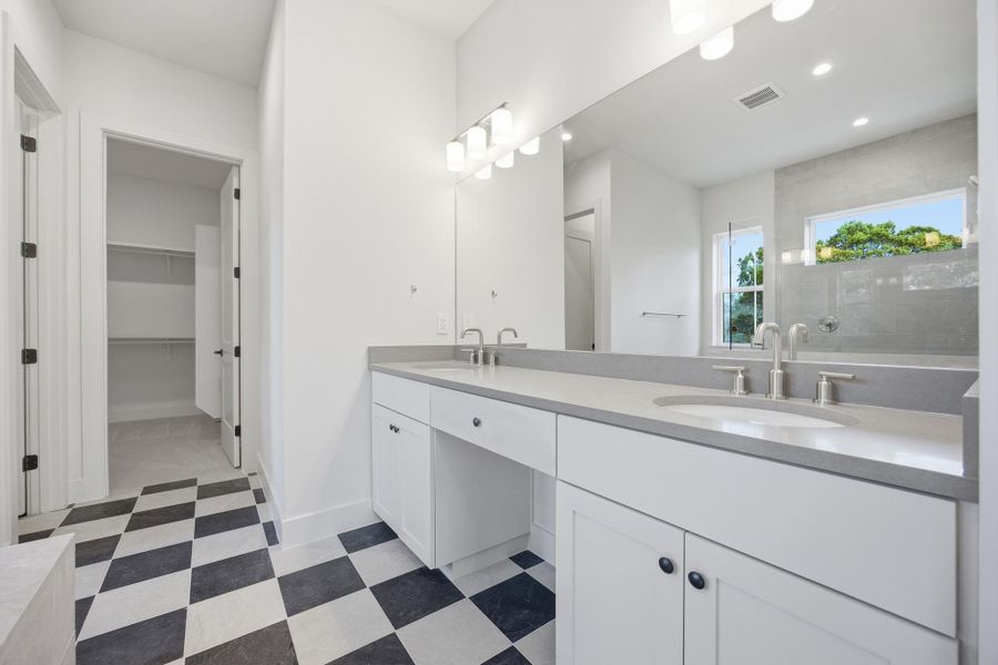 Primary ensuite, double vanity, a spacious closet, and walk in zero threshold shower