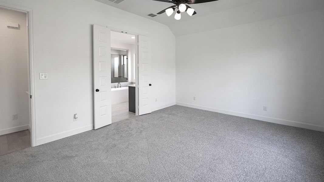 Unfurnished bedroom featuring light carpet, ensuite bath, and ceiling fan Unfurnished bedroom featuring light carpet, ensuite bath, and ceiling fan