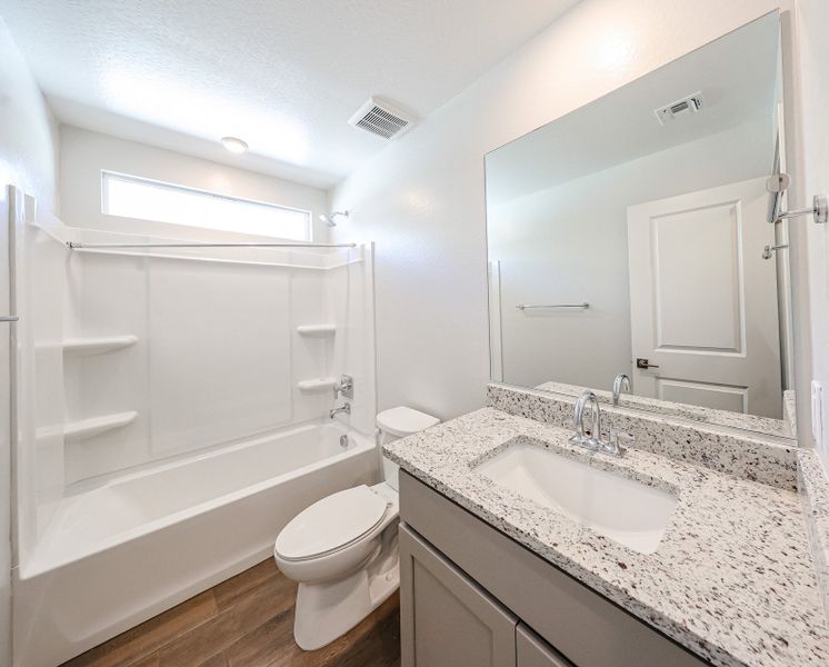 A bathroom with a tub sink and toilet.