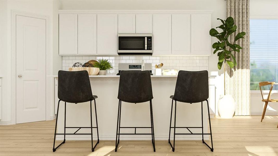 Kitchen featuring a breakfast bar, backsplash, light hardwood / wood-style floors, and white cabinetry