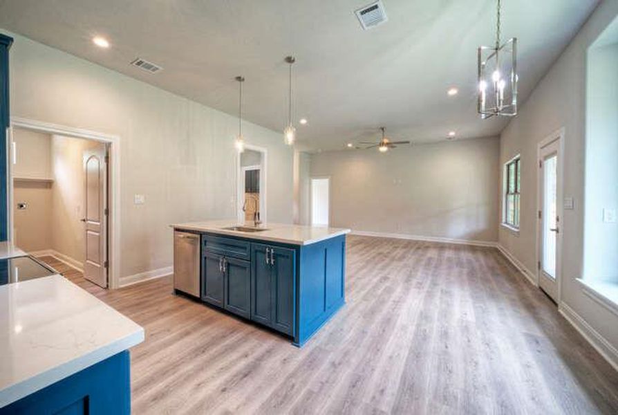 Kitchen featuring blue cabinetry, light wood-style floors, pendant lighting, ceiling fan, and dishwasher
