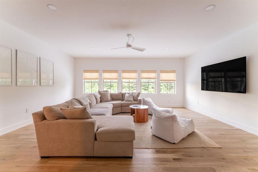 Living area featuring wood finished floors and a ceiling fan Living area featuring wood finished floors and a ceiling fan