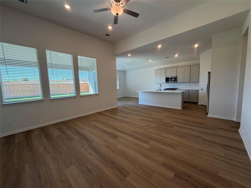 Unfurnished living room with dark wood-style floors, recessed lighting, and a ceiling fan Unfurnished living room with dark wood-style floors, recessed lighting, and a ceiling fan