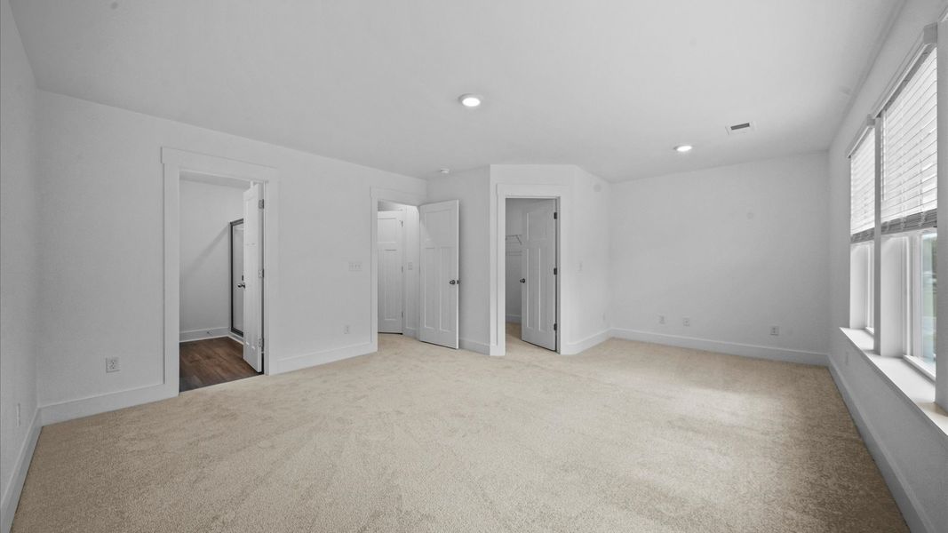 Eye-catching details and elegant finishes in the vibrant primary suite of this select townhome at Ransdell Pointe