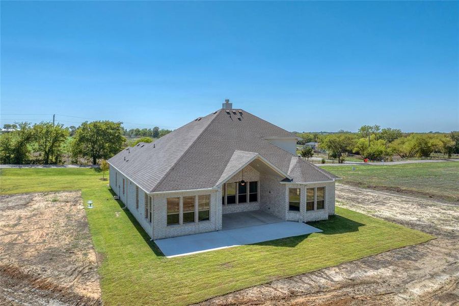 Rear view of property featuring a yard and a patio