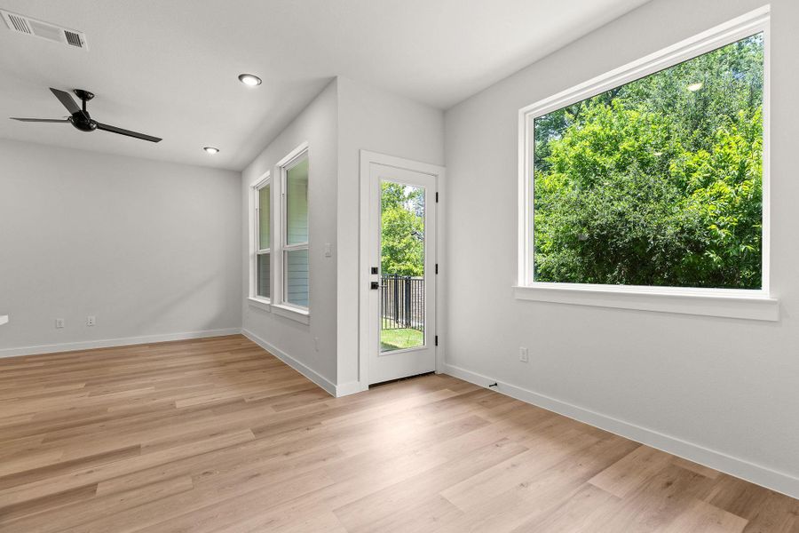 Natural light floods this inviting living space, highlighting the wood flooring and modern recessed lighting.