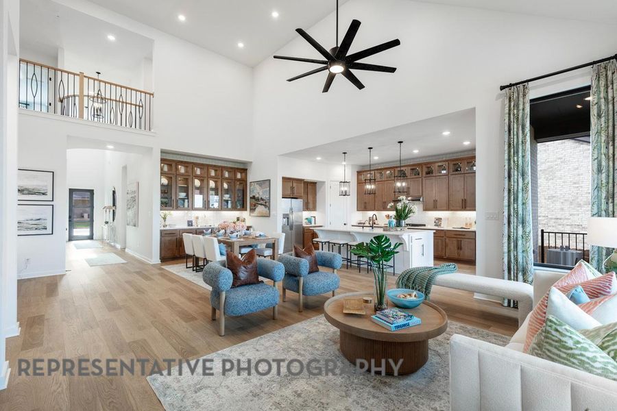 Living room featuring light wood-type flooring, high vaulted ceiling, ceiling fan, and recessed lighting