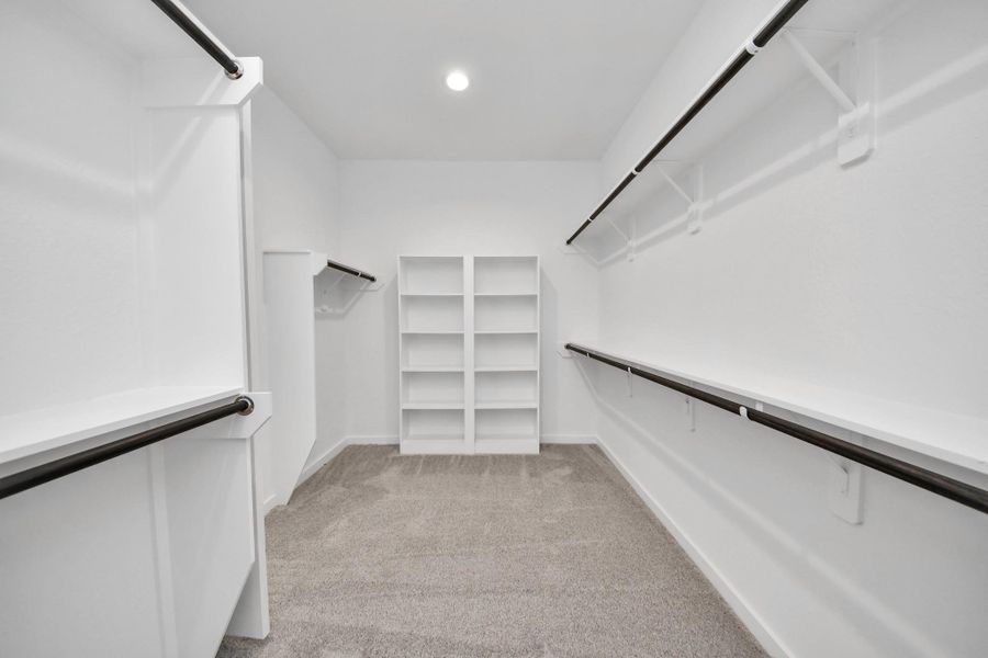 Walk-in closet that epitomizes luxury and practicality. This generously sized space features built-in shelving, offering abundant room for impeccable organization. High ceilings and recessed lighting create a bright and welcoming ambiance.