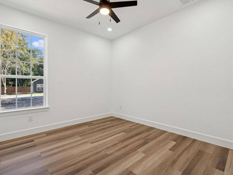 Spare room featuring hardwood / wood-style floors, plenty of natural light, and ceiling fan