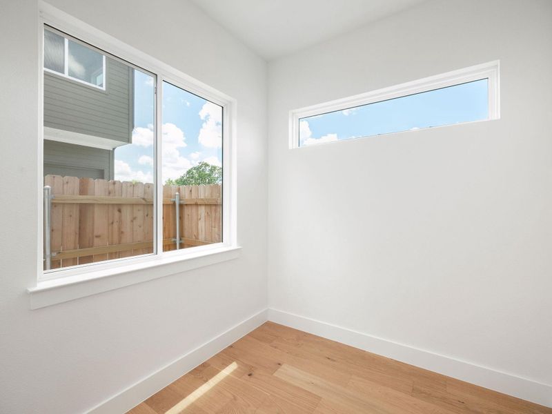 Sun-filled room boasts clean lines and warm hardwood flooring.