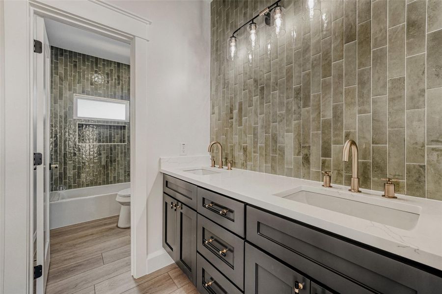 The full secondary bathroom upstairs features sleek modern finishes and a spacious dual vanity.