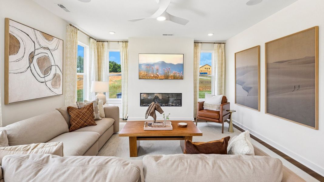 Gathering room with ceiling fan, windows, and fireplace Gathering room with ceiling fan, windows, and fireplace