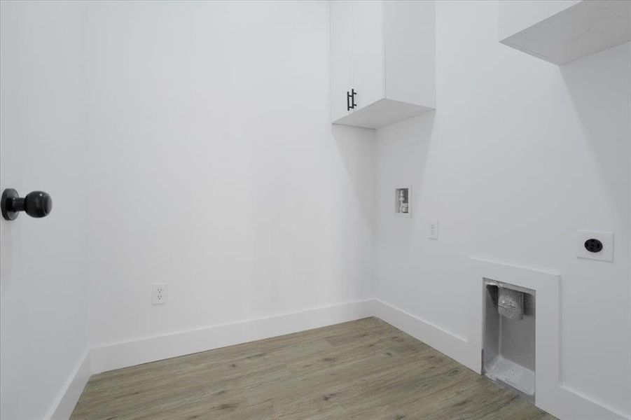 Laundry area featuring electric dryer hookup, light hardwood / wood-style floors, cabinets, and hookup for a washing machine