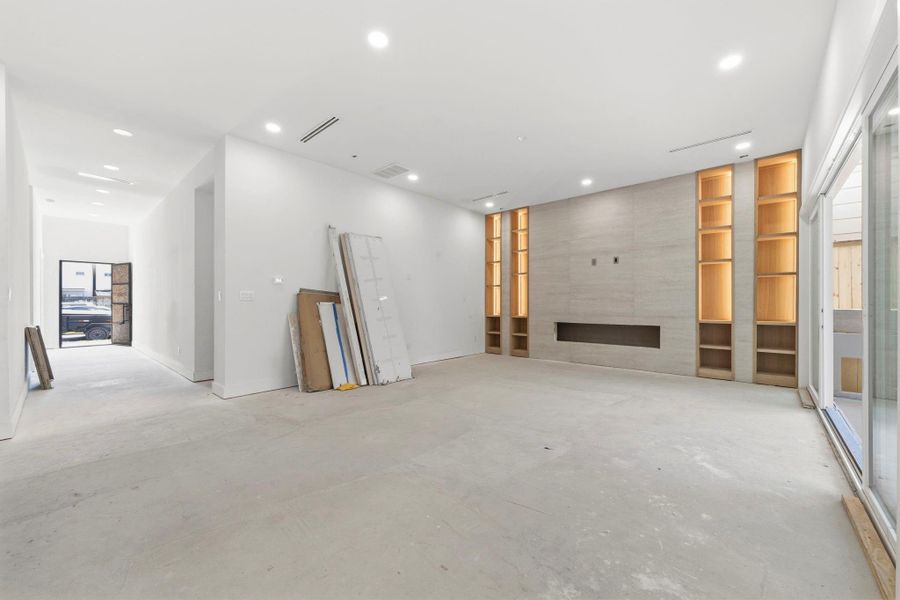 This photo shows the main living area. The porcelain, floor-to-ceiling wall houses an electric fireplace and is framed by white oak custom shelving and cabinetry. This photo shows the main living area. The porcelain, floor-to-ceiling wall houses an electric fireplace and is framed by white oak custom shelving and cabinetry.
