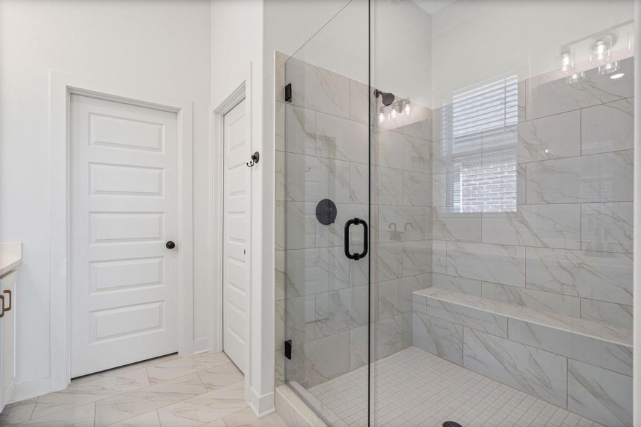 Full bathroom with a marble finish shower, vanity, and light marble finish flooring