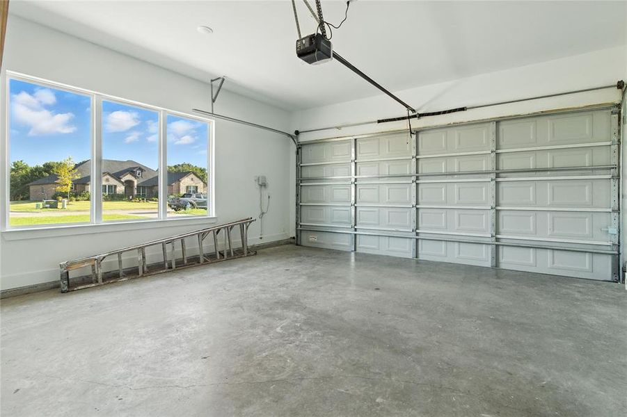 Garage with baseboards and a garage door opener Garage with baseboards and a garage door opener