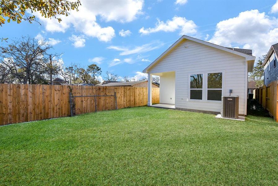 Relax and unwind in this serene backyard oasis, featuring a pristine lawn and a fabulous covered patio—perfect for outdoor dining and entertaining.