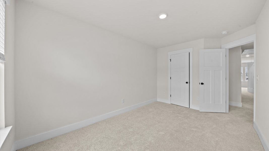 Elegant bedroom retreat featuring soft carpeting and a thoughtfully designed walk-in closet Elegant bedroom retreat featuring soft carpeting and a thoughtfully designed walk-in closet