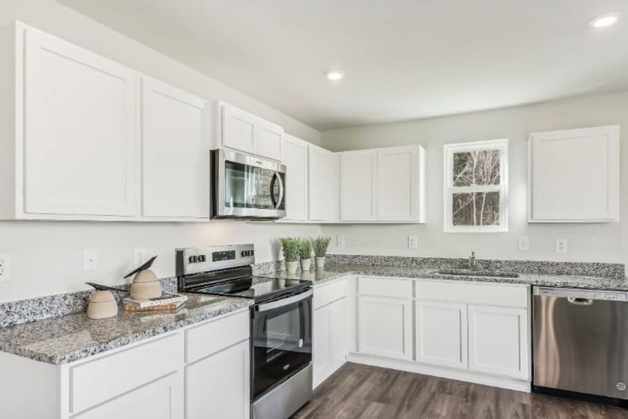A kitchen with white cabinets.