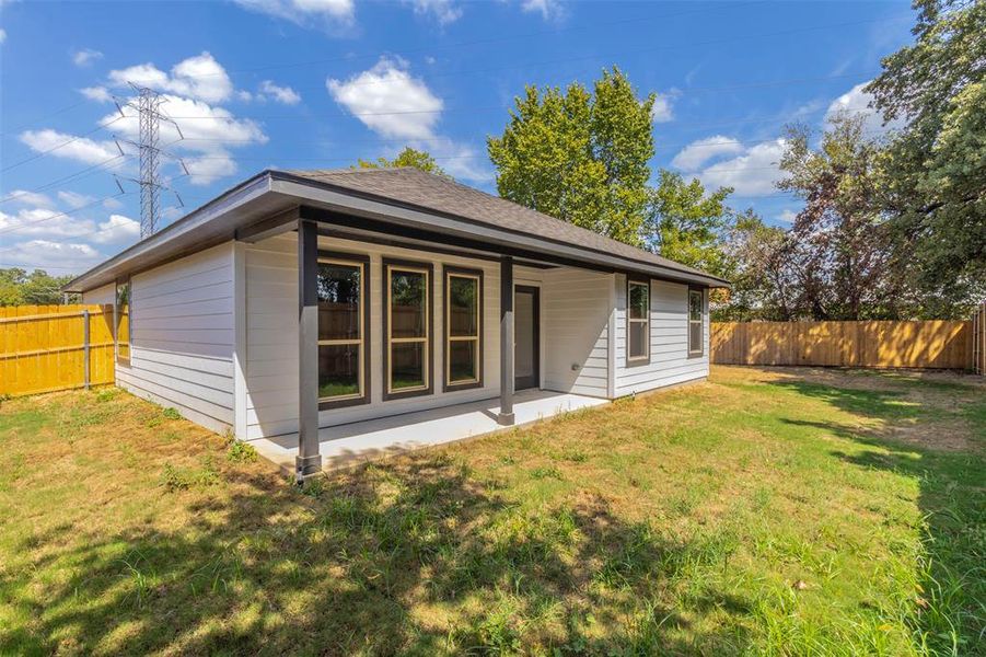 Rear view of property with a lawn and a patio