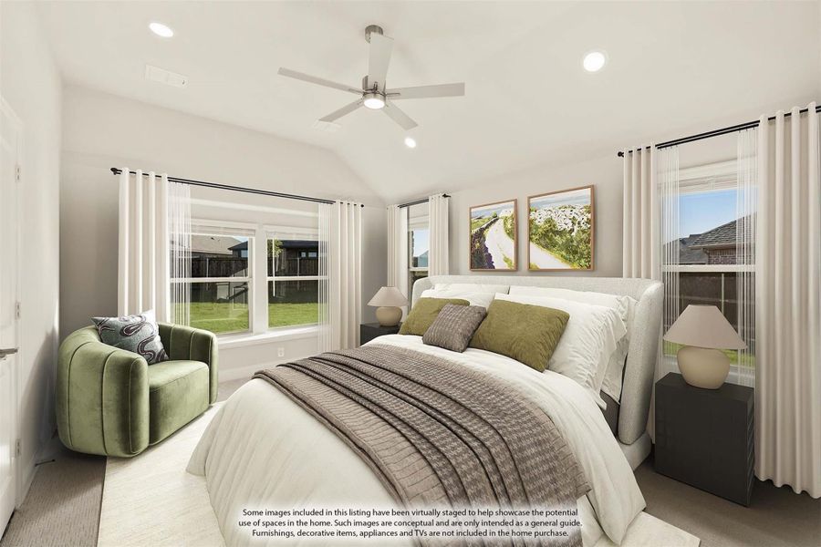 Bedroom with vaulted ceiling, ceiling fan, large windows, and upholstered bed with green accent chair