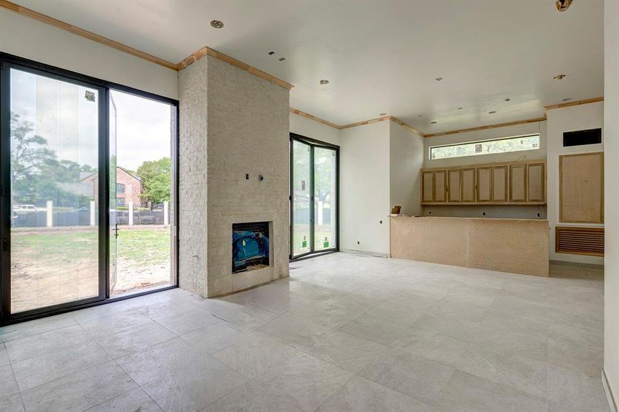 Incredible indoor/outdoor living room with fireplace and summer kitchen. Large glass doors open to the pool area. Stage of construction as of April 3, 2025. Incredible indoor/outdoor living room with fireplace and summer kitchen. Large glass doors open to the pool area. Stage of construction as of April 3, 2025.