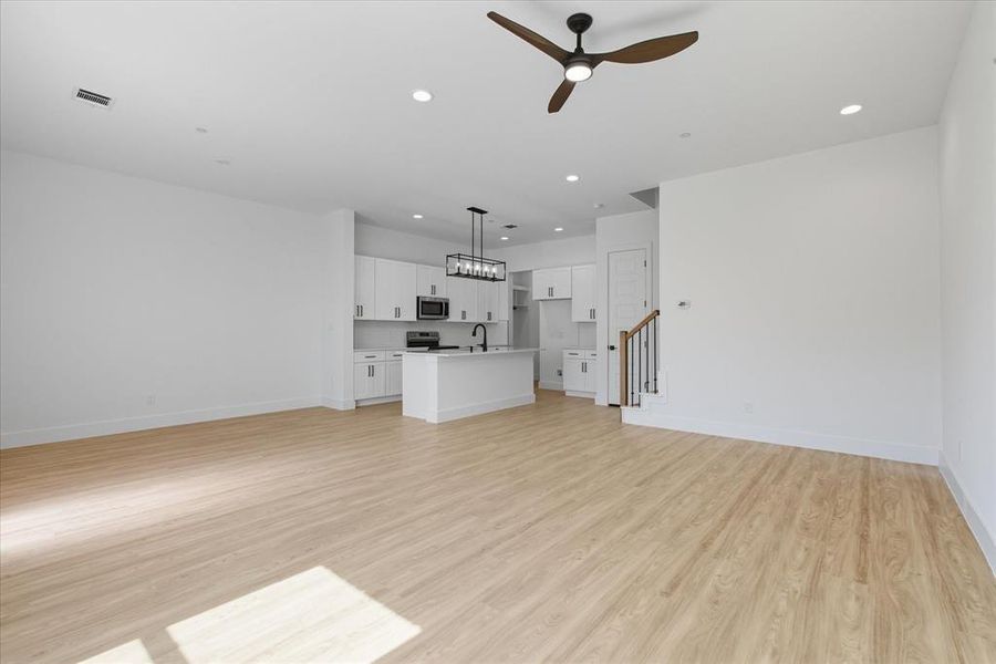 Unfurnished living room with a ceiling fan, recessed lighting, and light wood finished floors