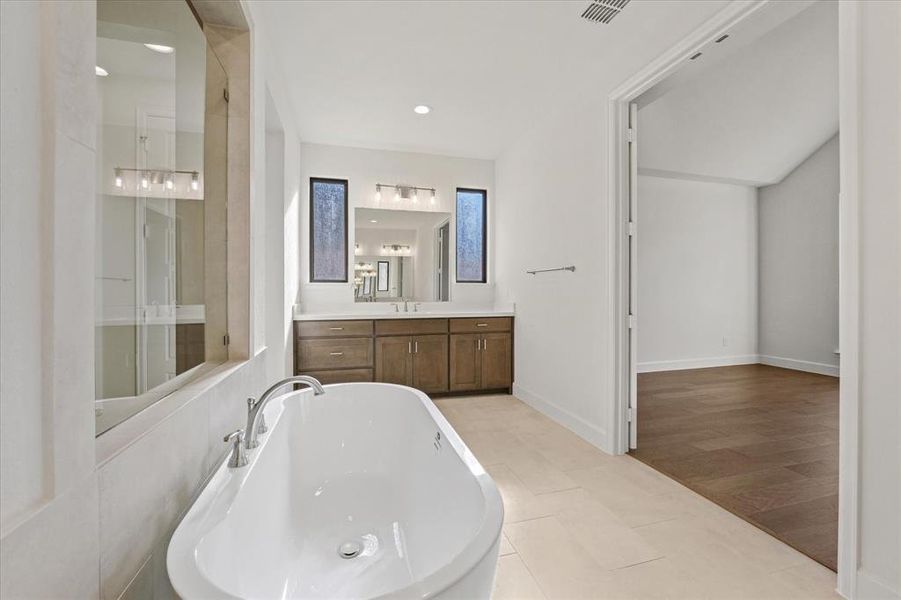 Bathroom featuring a freestanding tub, vanity, light tile patterned floors, recessed lighting, and a shower