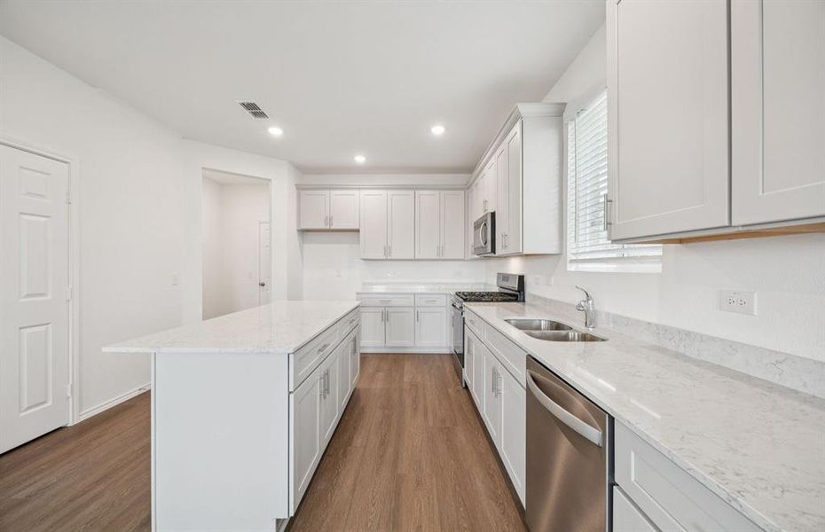 Large island overlooking gathering room and dining areas