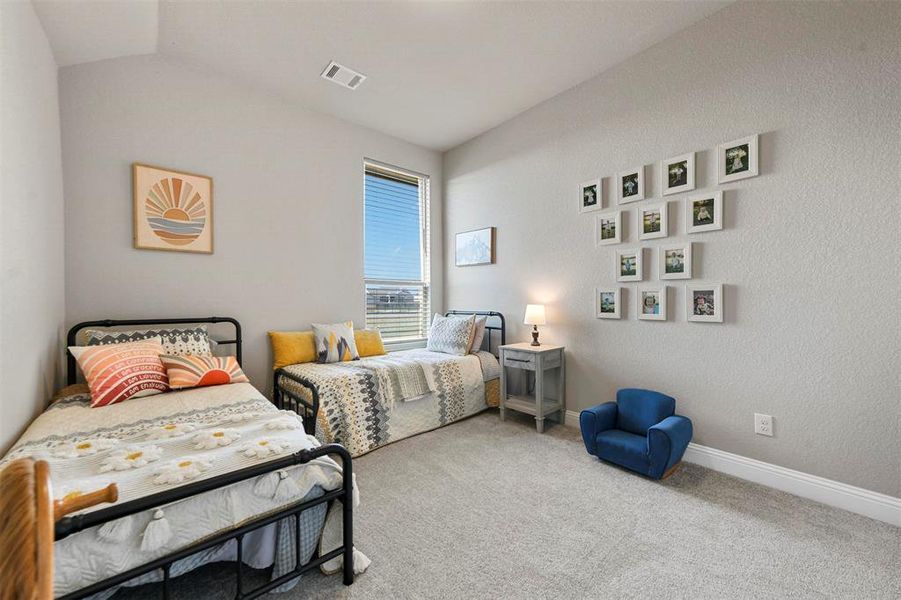 Carpeted bedroom featuring vaulted ceiling