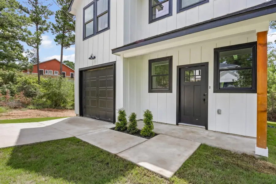 Property entrance featuring an attached garage and board and batten siding Property entrance featuring an attached garage and board and batten siding