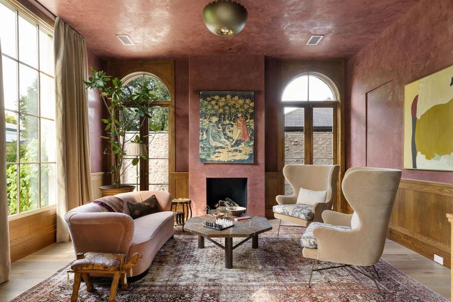 Sitting room featuring wood finished floors, a wainscoted wall, a fireplace, and wooden walls