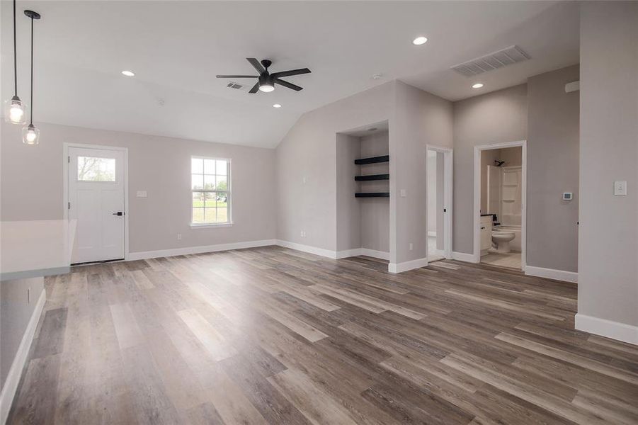 The large living room provides a modern LED ceiling fan and a sophisticated built-in niche for your media credenza with beautifully stained wood shelving above.