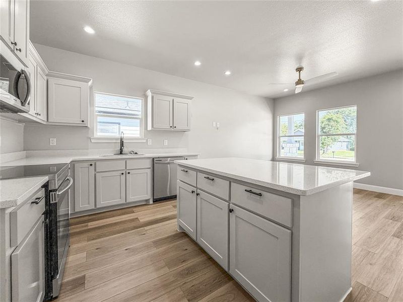 Modern kitchen featuring a central island with countertop seating space Modern kitchen featuring a central island with countertop seating space