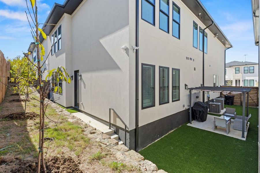 Rear view of property featuring a fenced backyard, a patio area, and stucco siding