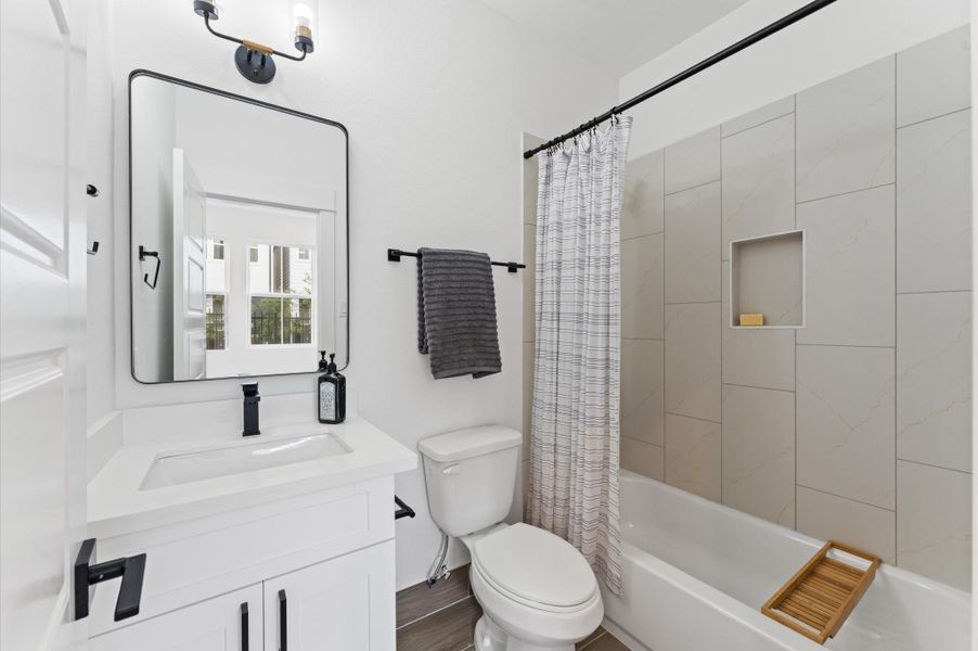 Conveniently located within the first-floor bedroom, this ensuite secondary bathroom offers both style and practicality. The tub-shower combo is framed with classic tilework and modern fixtures, making it ideal for quick rinses or relaxing soaks.