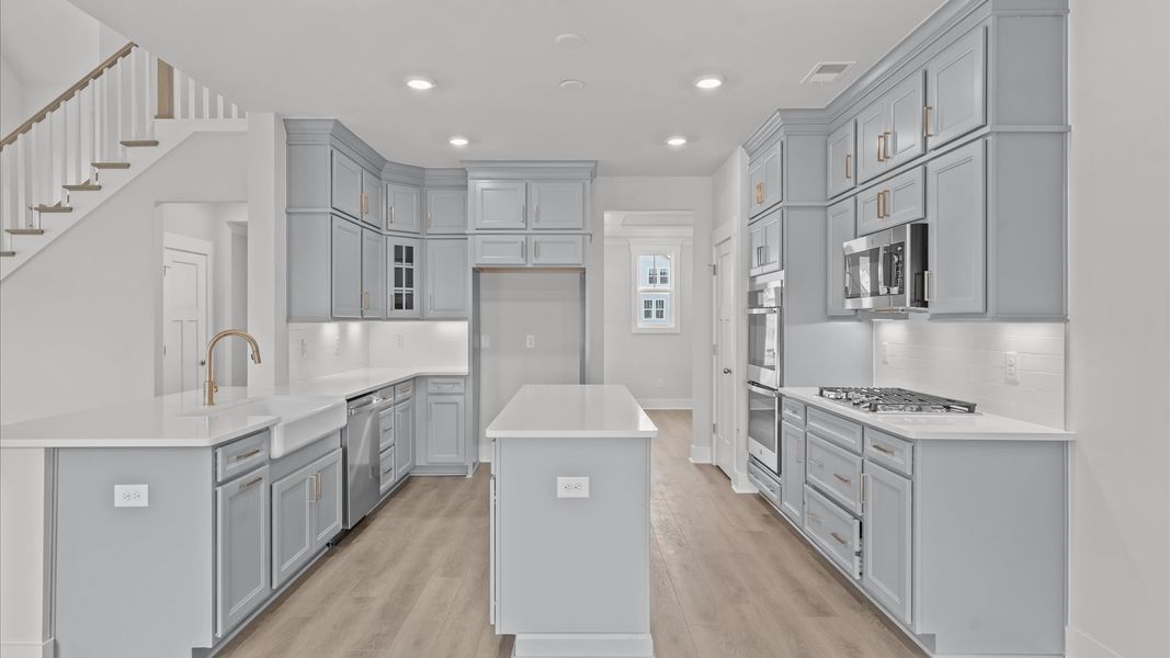 Highly skilled kitchen design includes a 9-foot island, quartz countertops, and stylish pendant fixtures