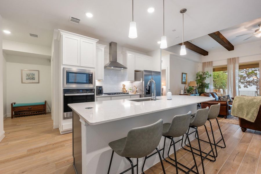 Bright, open-concept kitchen with a spacious island, seamlessly flowing into a living area with exposed beams and captivating views. Bright, open-concept kitchen with a spacious island, seamlessly flowing into a living area with exposed beams and captivating views.